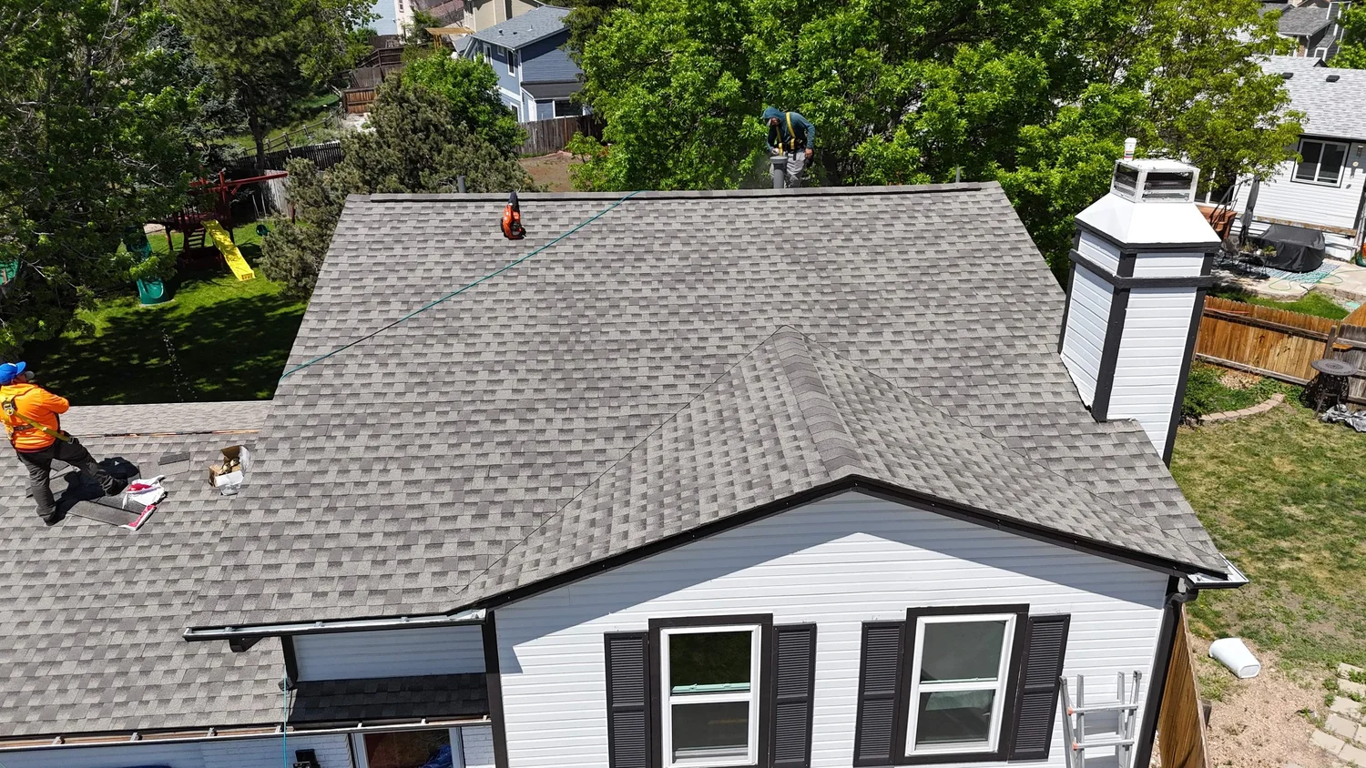 Completed roof replacement on a white Colorado home
